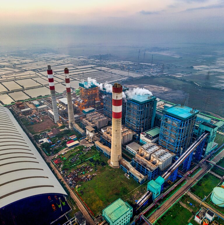 Aerial shot of a power plant with smokestacks in Banten, Indonesia, showcasing industrial infrastructure.